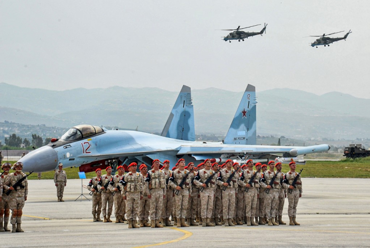 Des troupes russes, un chasseur Su-35 et des hélicoptères Mi-24, lors d'un défilé à la base de Hmeimim, en mai 2021 ( SANA / - )