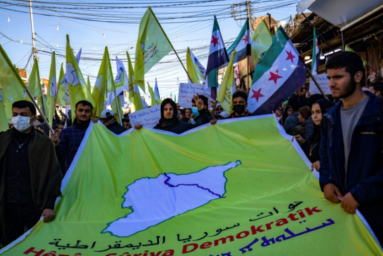 Des manifestants kurdes agitent le drapeau à trois étoiles de l'indépendance syrienne, le 19 décembre 2024 à Qamichli, dans le nord de la Turquie ( AFP / Delil SOULEIMAN )