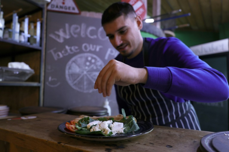 Un chef prépare un plat avec du fromage de lait d'ânesse, au restaurant Oxhaket à Tirana, le 4 décembre 2024 en Albanie ( AFP / Adnan Beci )