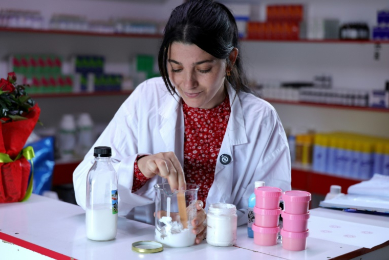 La pharmacienne Abjola Meci mélange des ingrédients naturels avec du lait d'ânesse pour réaliser une crème pour le visage au laboratoire de LEVA Cosmetics, à Gjirokaster, le 28 novembre 2024 en Albanie ( AFP / Adnan Beci )