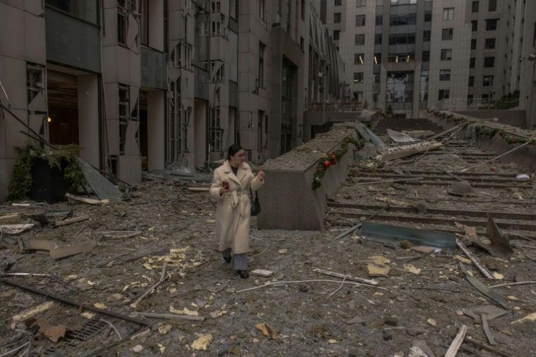 Une femme marche parmi les débris après une attaque de missiles russe contre Kiev, la capitale ukrainienne, le 20 décembre 2024 ( AFP / Roman PILIPEY )