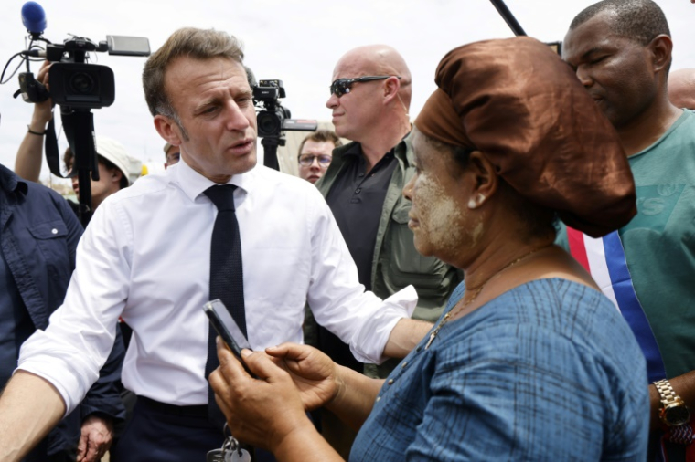 Emmanuel Macron parle avec une habitante à Tsingoni, à Mayotte, le 20 décembre 2024 ( POOL / LUDOVIC MARIN )