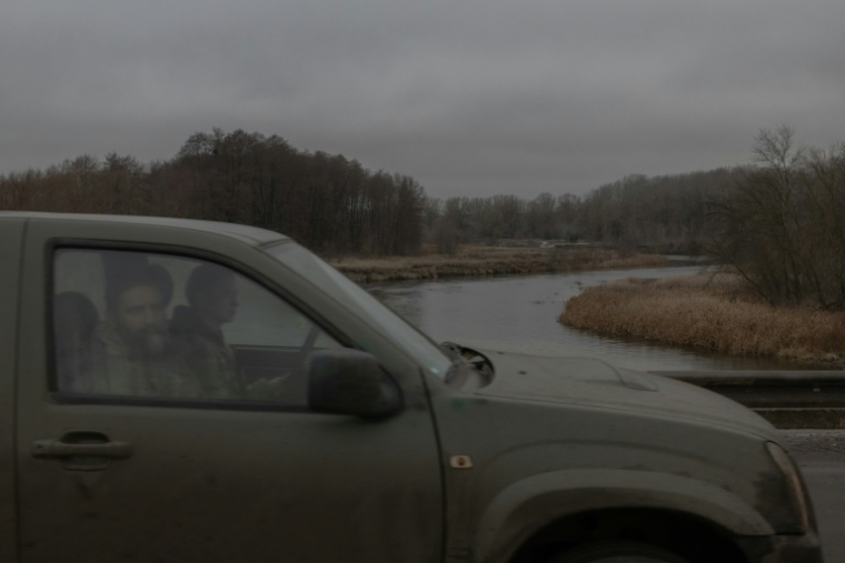 Des soldats ukrainiens conduisent une voiture le long de la rivière Oskil dans le village d'Oskil, dans la région de Kharkiv, le 8 décembre 2024 ( AFP / Roman PILIPEY )