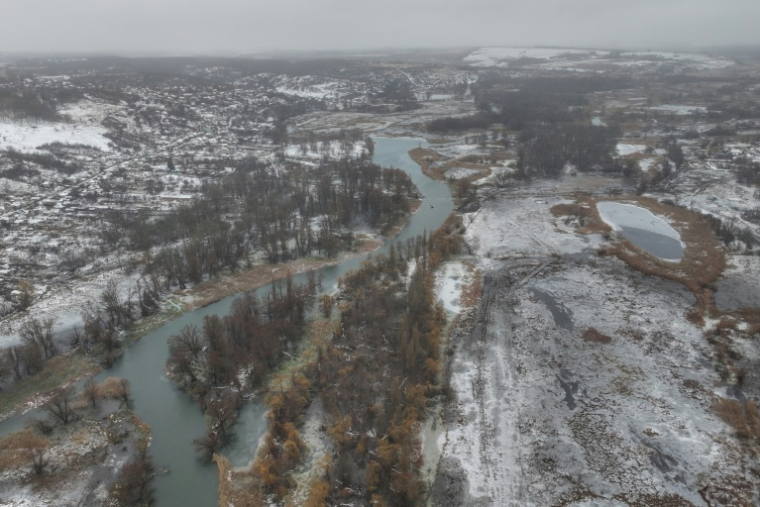 Vue aérienne de la rivière d'Oskil dans le district de Kupiansk de la région de Kharkiv, entourée de vastes champs recouverts de neige, parsemés de bunkers ukrainiens et de tranchées le 15 décembre 2024 ( AFP / Roman PILIPEY )