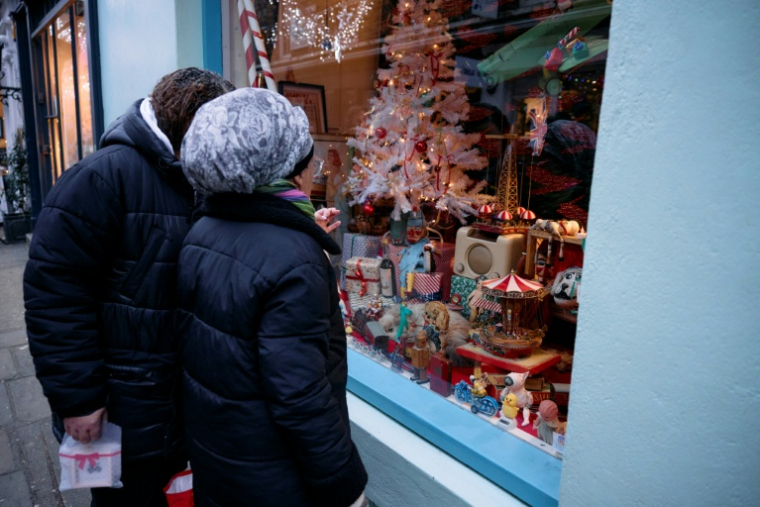 Des passants s'arrêtent devant la vitrine du 43 Camden Passage à Londres, le 20 décembre 2024 ( AFP / BENJAMIN CREMEL )