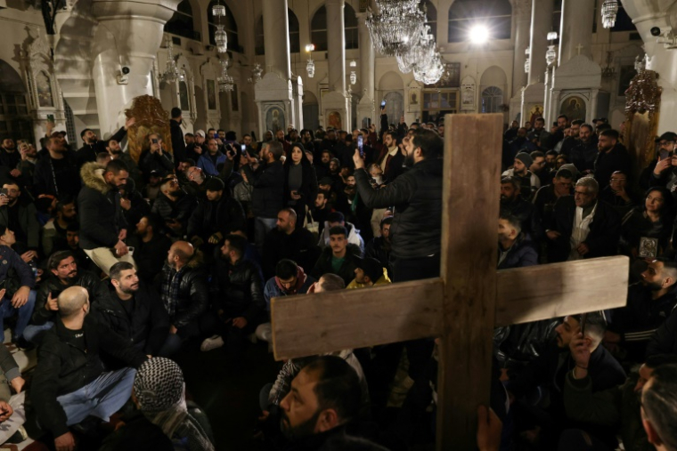 Des fidèles chrétiens rassemblés dans une église à Damas, le 24 décembre 2024 en Syrie ( AFP / ANWAR AMRO )