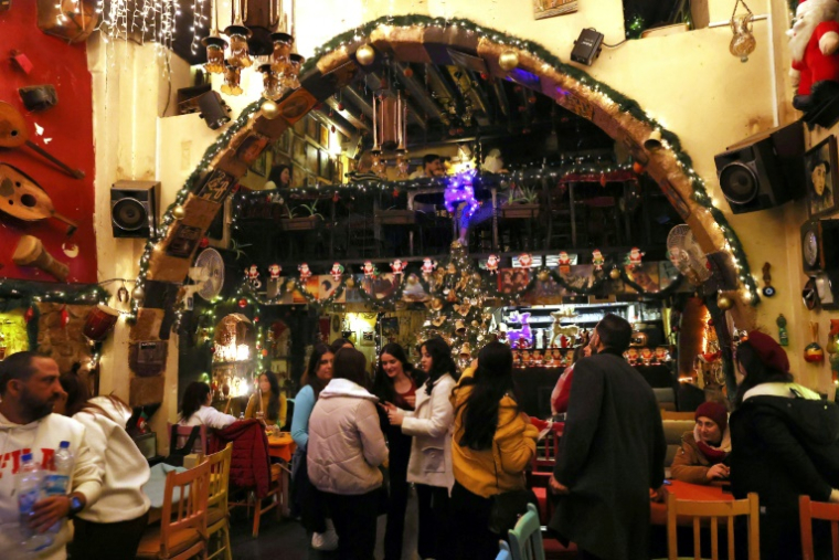 Un sapin  et des décorations de Noël dans un café du quartier à majorité chrétienne de Bab Touma à Damas, le 23 décembre 2024 en Syrie ( AFP / ANWAR AMRO )