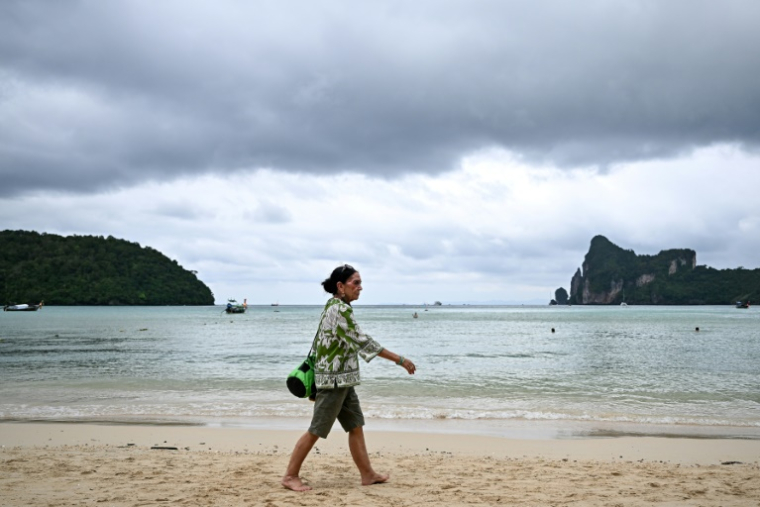 Elisabeth Zana, fondatrice de l'association NAT, qui a perdu sa fille Natacha dans le tsunami de 2004, marche sur une plage en direction du parc commémoratif du tsunami à Koh Phi Phi, le 21 novembre 2024 en Thaïlande ( AFP / Manan VATSYAYANA )