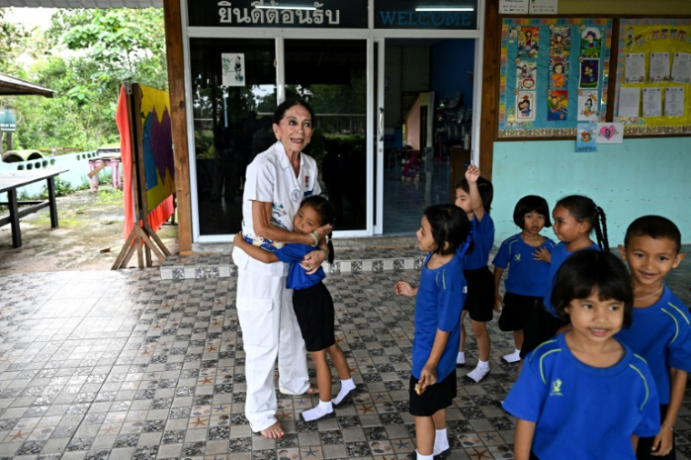 Elisabeth Zana et les enfants de l'école Bankuankojan de Krabi, également connue sous le nom d'"école Natacha", en mémoire de sa fille Natacha décédée lors du tsunami de 2004, le 22 novembre 2024 en Thaïlande ( AFP / Manan VATSYAYANA )