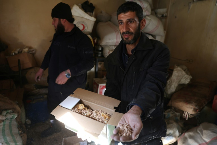 Un homme montre une boîte contenant des pilules de captagon, à Damas le 25 décembre 2024 ( AFP / OMAR HAJ KADOUR )