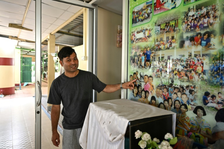 Wattana Sittirachot, qui a perdu son oncle lors du tsunami de 2004, montre des vieilles photos à la fondation Baan Than Nam Chai, le 20 novembre 2024 dans la province de Phang Nga, en Thaïlande ( AFP / Manan VATSYAYANA )