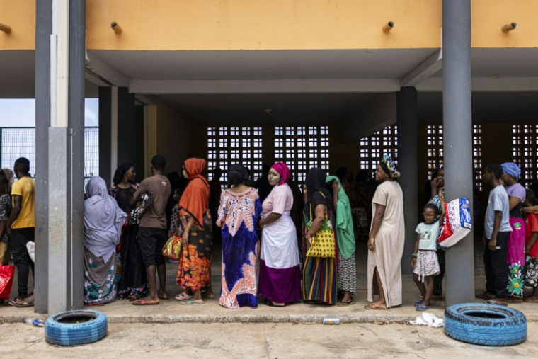 Des habitants de Mayotte font la queue pour recevoir de la nourriture et de l'eau lors d'une distribution à Mtsahara, le 25 décembre 2024 ( AFP / PATRICK MEINHARDT )