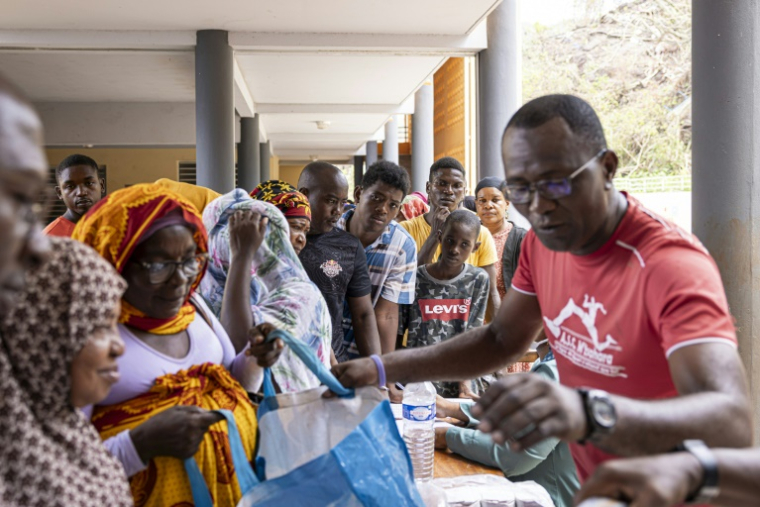 Des habitants de Mayotte font la queue pour recevoir de la nourriture et de l'eau lors d'une distribution à Mtsahara, le 25 décembre 2024 ( AFP / PATRICK MEINHARDT )