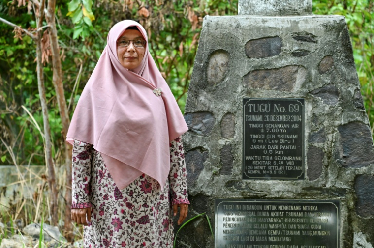 L'enseignante Marziani, qui a perdu un enfant dans le tsunami de 2004, à côté d'un monument à Pekan Bada, près de Banda Aceh, le 21 novembre 2024 en Indonésie ( AFP / CHAIDEER MAHYUDDIN )