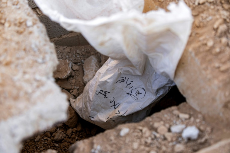 Des sacs renfermant des ossements après leur découverte sur un site qui serait une fosse commune à Adra, à environ 35 kilomètres à l'est de Damas, le 25 décembre 2024 ( AFP / Sameer Al-DOUMY )