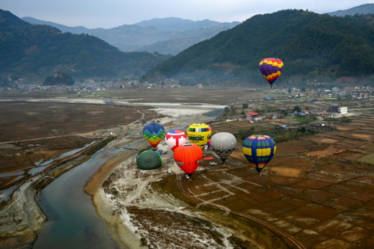 Des montgolfières s'élèvent dans le ciel lors du premier festival de montgolfières du Népal, à Pokhara, le 24 décembre 2024 ( AFP / PRAKASH MATHEMA )