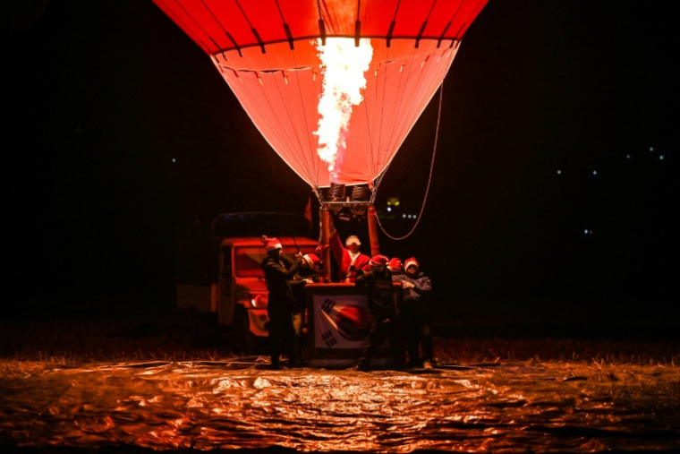 Des participants au premier festival de montgolfières du Népal à Pokhara, le 24 décembre 2024 ( AFP / Prakash MATHEMA )