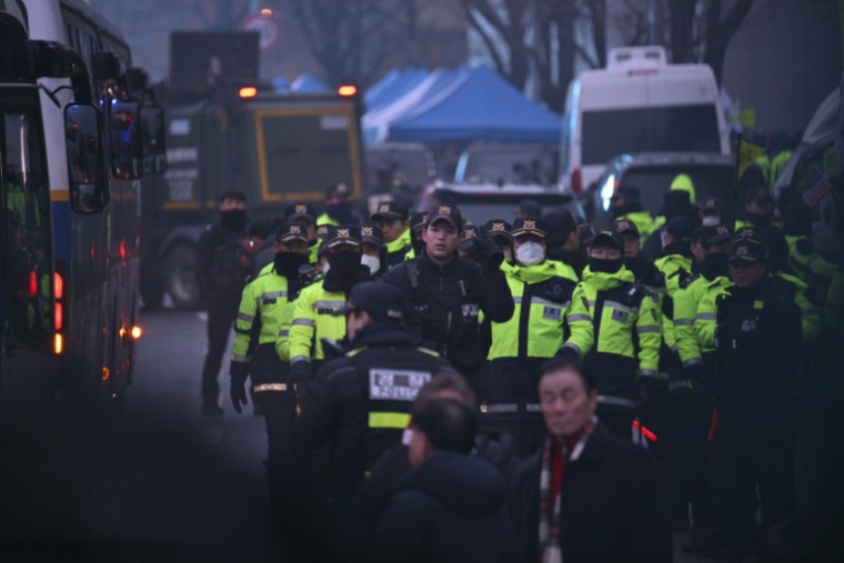 Des policiers devant la résidence du président déchu sud-coréen Yoon Suk Yeol le 6 janvier 2025 ( AFP / ANTHONY WALLACE )