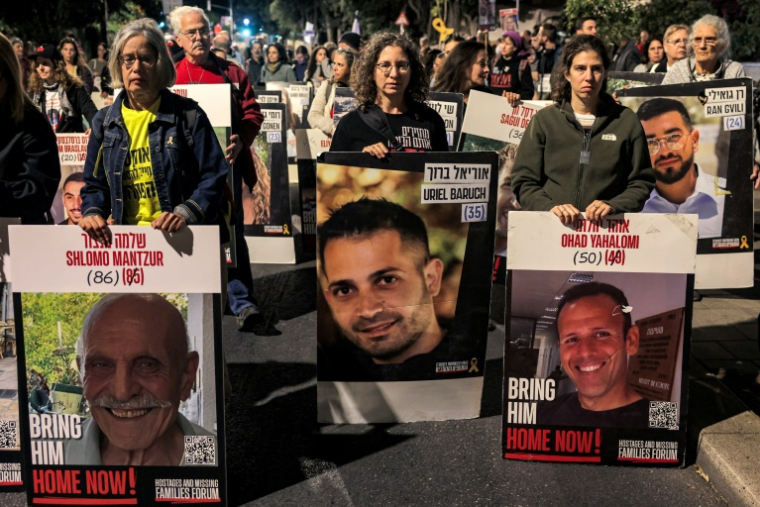 Des manifestants portent des portraits d'otages israéliens dont Shlomo Mantzur, Uriel Baruch, Ohad Yahalomi et Ran Gvili, le 24 octobre 2024 à Jérusalem ( AFP / Ahmad GHARABLI )